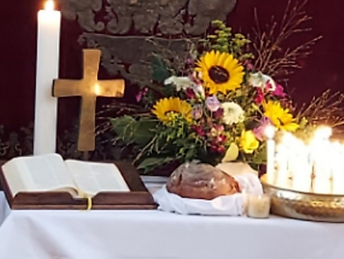 Altar eingedeckt mit Brot, Kerzen und Kreuz