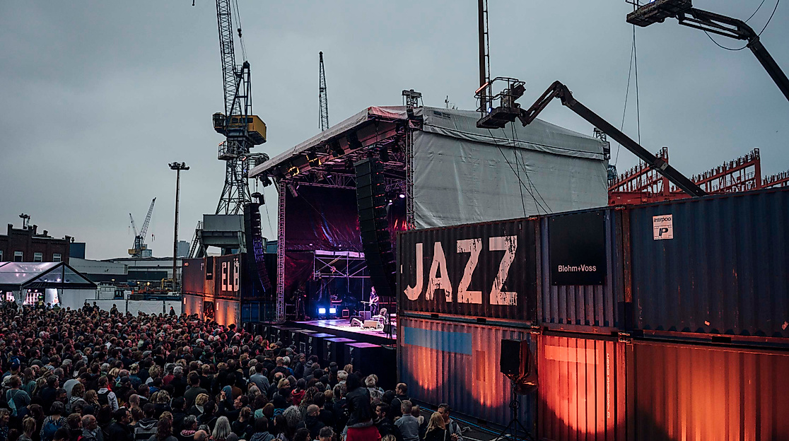 Open-Air-Bühne beim Elbjazz Festival im Hamburger Hafen, Container und Jazz-Schriftzug im Blick.