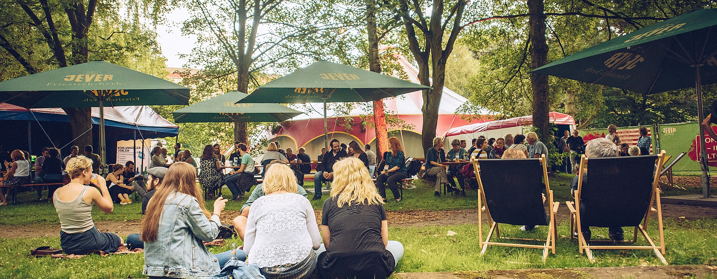 Menschen entspannen im Grünen auf Liegestühlen und Picknickdecken beim Open-Air-Event Sommer in Altona