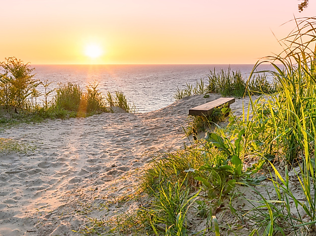 Sonnenuntergang über der Ostsee mit Bank am Küstenpfad – ruhiger Ausblick aufs Meer ab Hamburg