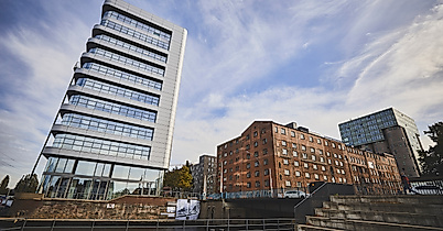 Moderne Gebäude am Lotsekanal in Harburg mit schrägem Büroturm und Uferpromenade