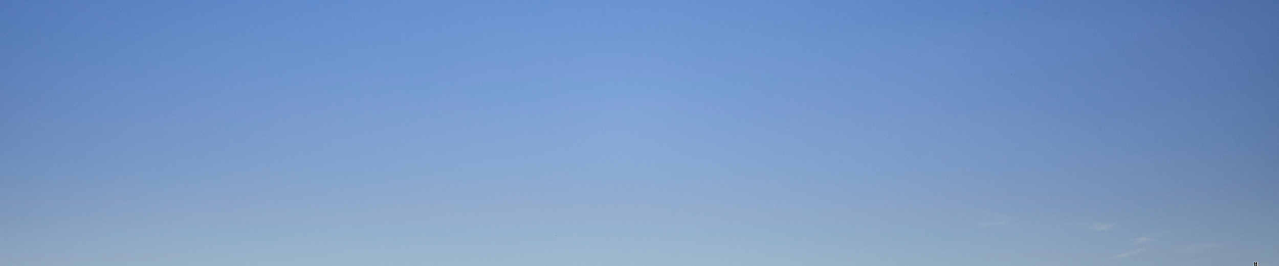 Blick über die Elbe in Hamburg bei blauem Himmel, mit Uferbebauung und Fernsehturm in der Ferne