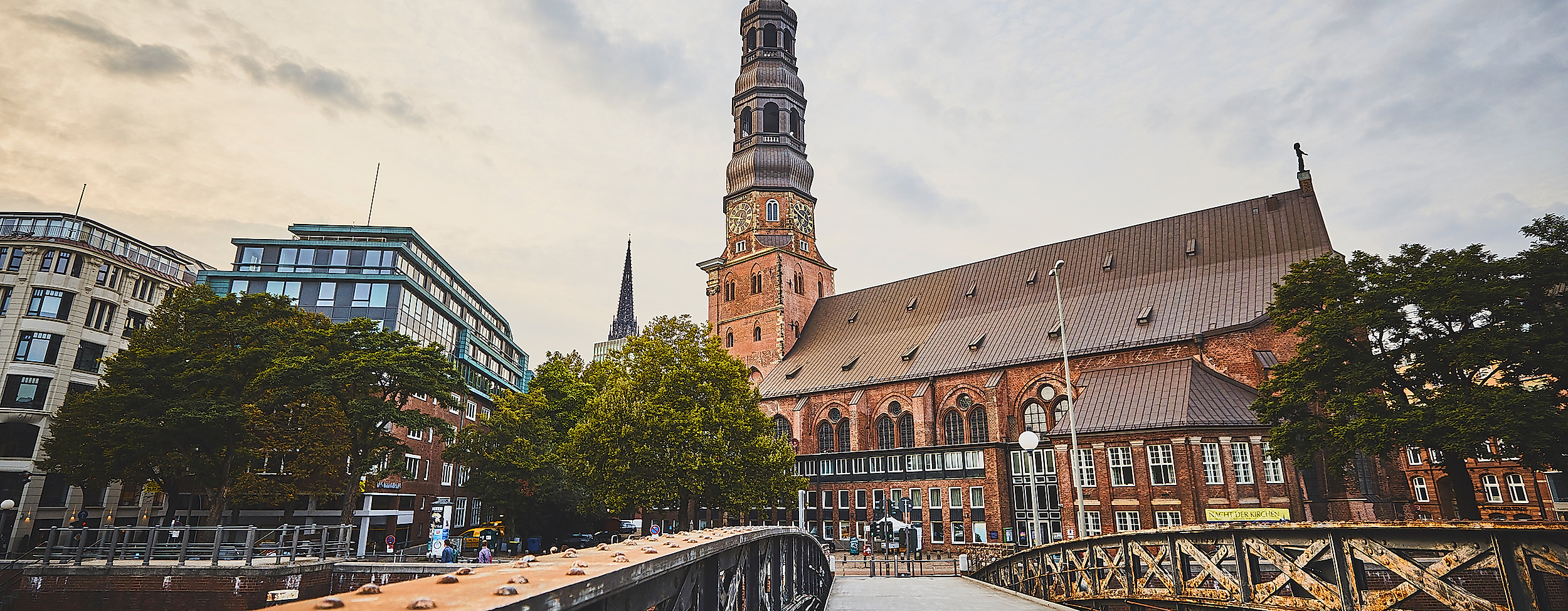 Backsteinkirche St. Katharinen mit markantem Turm, gesehen von einer Brücke bei Abendstimmung