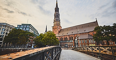 Backsteinkirche St. Katharinen mit markantem Turm, gesehen von einer Brücke bei Abendstimmung