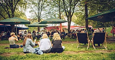 Menschen entspannen im Grünen auf Liegestühlen und Picknickdecken beim Open-Air-Event Sommer in Altona