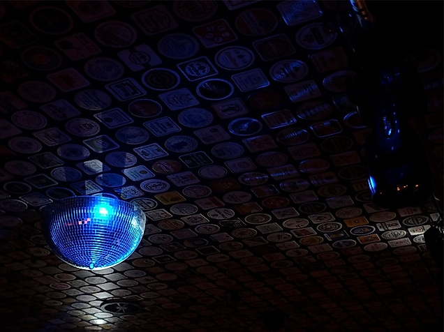 Blaue Discokugel wirft Lichtreflexe an die gemusterte Decke eines stilvollen Hamburger Clubs