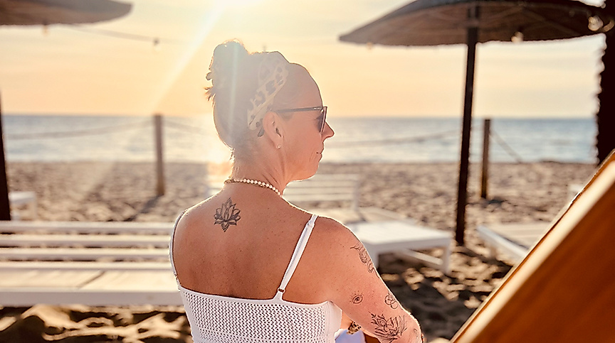 Frau sitzt am Strand von Scharbeutz und Haffkrug vor dem Strandyoga