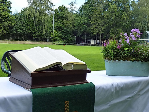 Aufgeschlagene Bibel und Blumenkorb auf einem Altar auf dem Fußballfeld