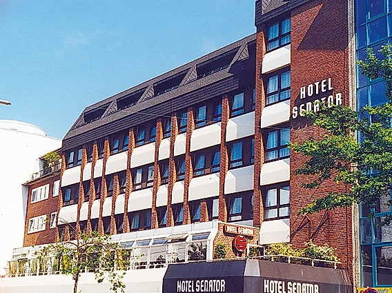 Mehrstöckiges Gebäude mit roter Fassade und weißem Schriftzug „Hotel Baseler Hof“ 