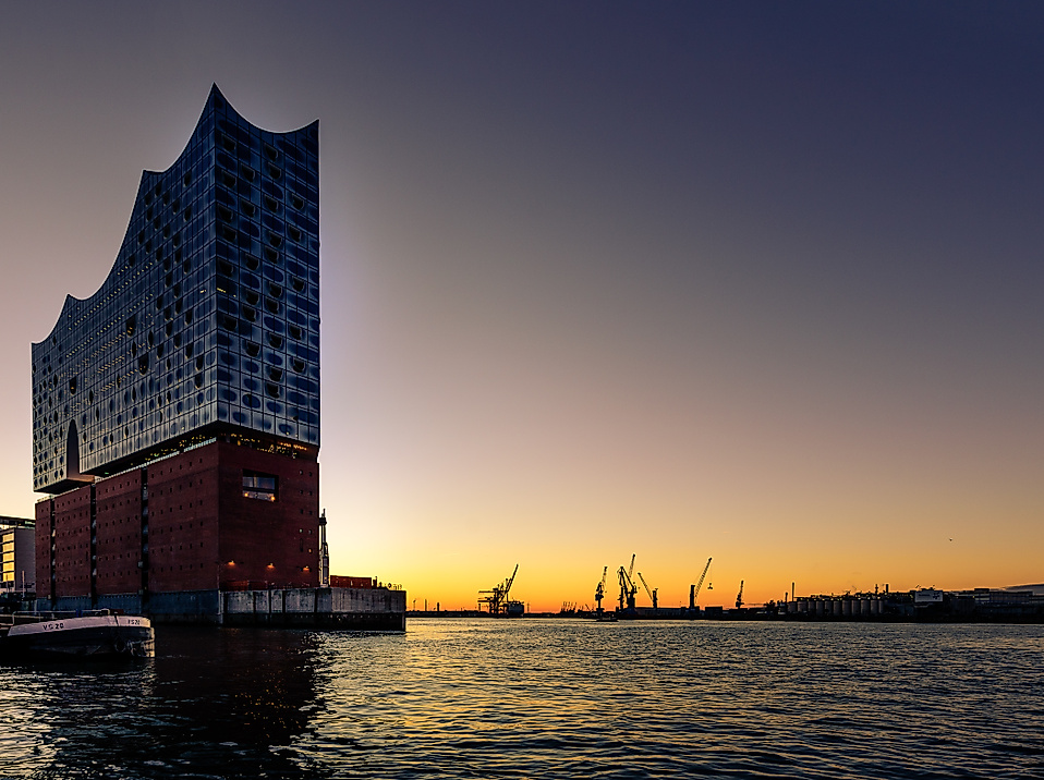 Elbphilharmonie von unten bei Sonnenuntergang mit Hafenblick