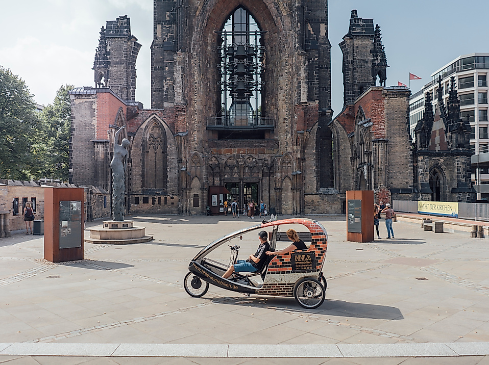 Rikscha mit Fahrgästen vor der Ruine der St.-Nikolai-Kirche im Zentrum von Hamburg