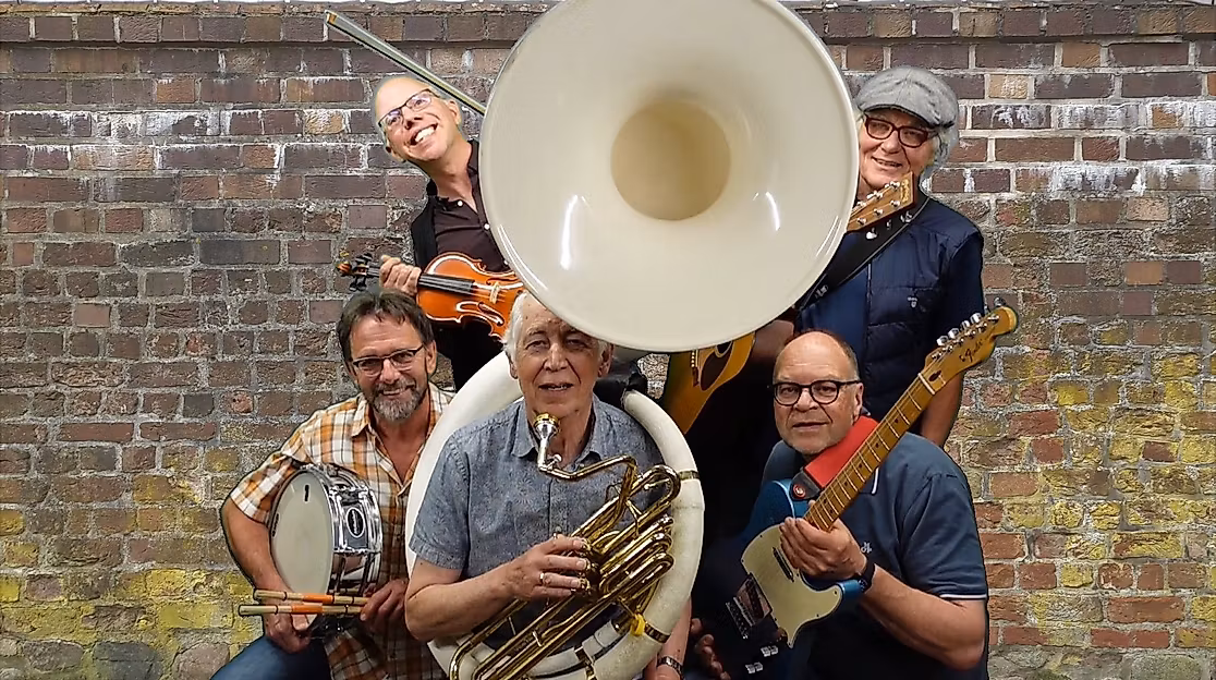 Musikgruppe vor Backsteinmauer