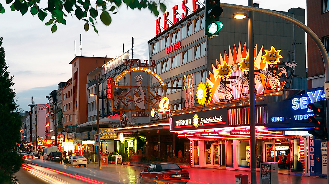 Beleuchtete Reeperbahn am Abend mit Theatern, Bars und Lichtspuren des Straßenverkehrs