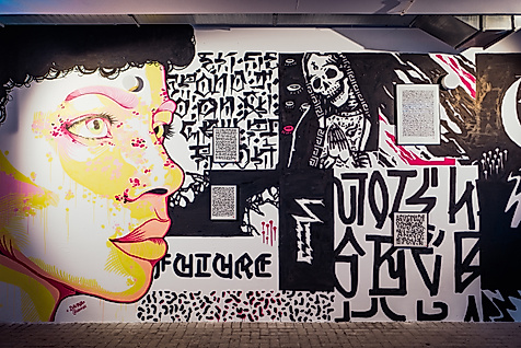 Schwarz-weißes Wandbild mit farbigem Porträt und Schriftzügen bei der Millerntor Gallery in Hamburg.