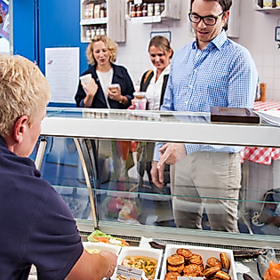 Kund:innen wählen Fischbrötchen an einer gut gefüllten Theke in Goedekens Kombüse aus