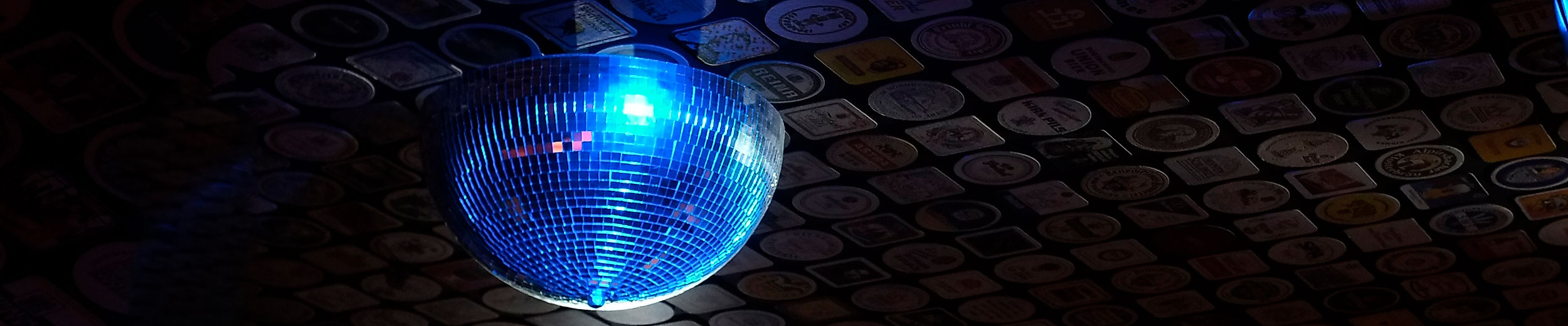 Blaue Discokugel wirft Lichtreflexe an die gemusterte Decke eines stilvollen Hamburger Clubs